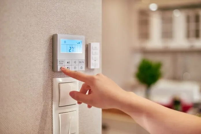 Woman,Hand,Adjusting,Temperature,/,Thermostat